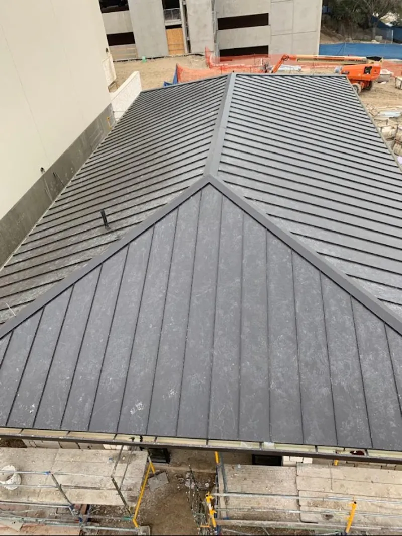 Commercial metal roof construction with crane equipment in Hugo